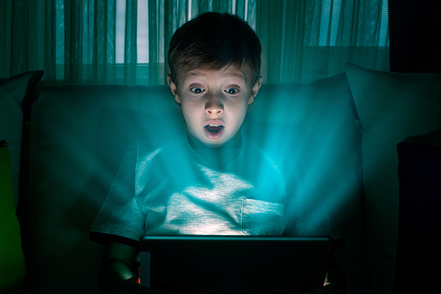 A young boy gasping at his tablet device